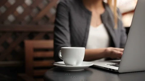 Close up of coffee Cup and hands typing on laptop Stock Footage 114107866