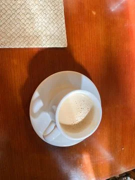 Close up of coffee cup on table at direct sunlight. morning coffee with steam Stock Photos