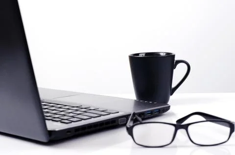 Close up of Coffee cups with labtop computer and eyeglasses on white backgr.. Stock-Fotos