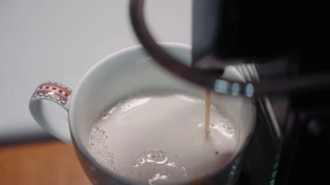 Close up of coffee dripping into mug with frothy milk 4k 60p Stock Footage 169760361