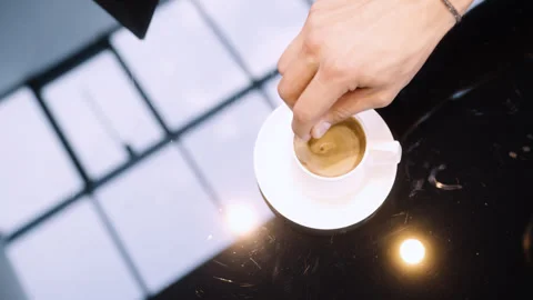 Close-Up of Coffee on Glass Table with Hand Stirring Stock Footage 281051910