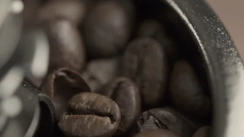 Close-up of coffee grinder with roasted coffee beans on wooden background Video stock 84770481
