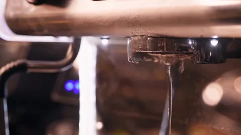 A close-up of coffee machine, drops of hot water fall down, then a hand fixes a Stock Footage 151205370