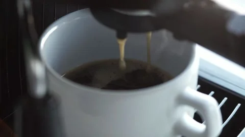 A close-up of a coffee maker filling coffee into a white cup. Stock Footage 201291735