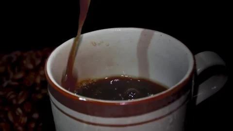 Close-up of Coffee Pour Into Cup with black background. Stock Footage 323782044