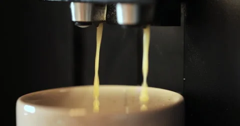 Close-up of coffee pouring from automatic coffee machine. Beverage drink for Stock Footage 252754339