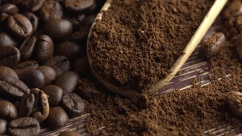 Close-up of coffee spoon with roasted coffee beans on wooden background Video stock 84769995