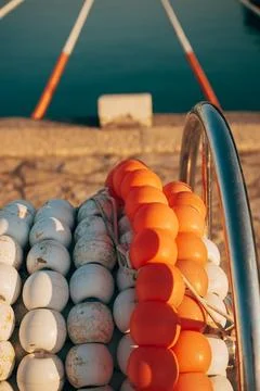 Close-up of coiled white and orange swimming pool buoy lane lines resting o.. Stock Photos