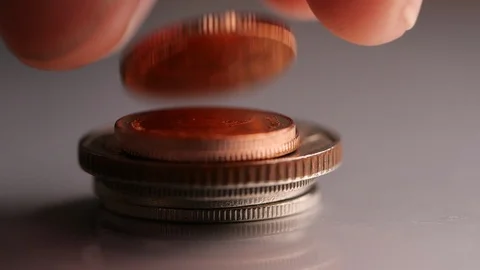 Close-up of Coin falling into stack of coin in slow motion Stock Footage 126017975