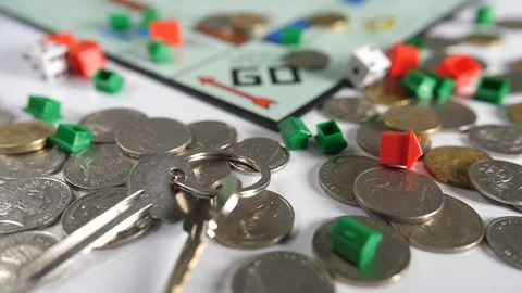 Close up of coins and double dice with new house door keys scattered  Stock Footage 89188061