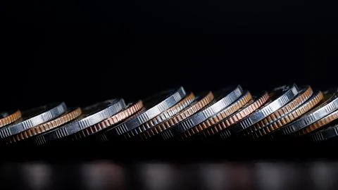Close up of Coins are lined up in front on table. background is black. Stock Photos