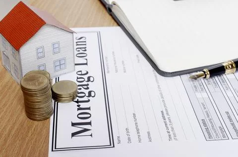 Close up of coins stack with house paper and mortgage loans application form 写真素材