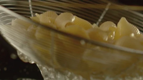 Close-up of colander with pasta pouring water. Slow motion video Stock Footage 116102035