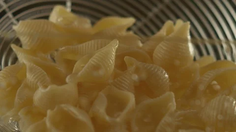 Close-up of colander with ready-made pasta drains water. Slow motion video Stock Footage 116102183