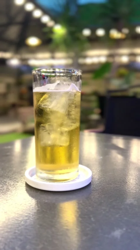 Close Up Cold Beer Glass with Foam on Dining Table at Night Stock Footage 293944751