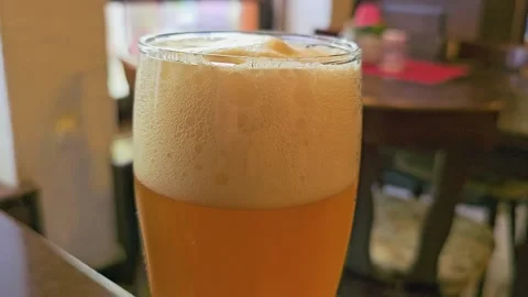 Close up of a cold beer glass with thick foam, golden color, bubbles Stock Footage 335267573