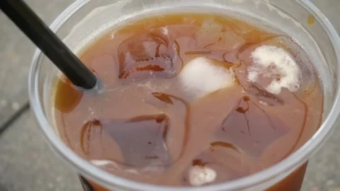 Close-up of cold coffee with ice in a glass and with a straw. Stock Footage 297624636