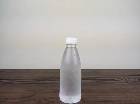 Close up cold plastic drink bottle on wooden table Stock Photos
