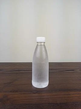 Close up cold plastic drink bottle on wooden table Stock Photos