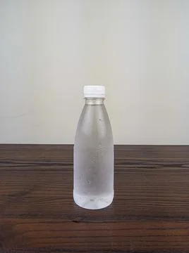 Close up cold plastic drink bottle on wooden table Stock Photos