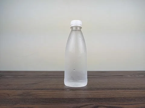 Close up cold plastic drink bottle on wooden table Stock Photos