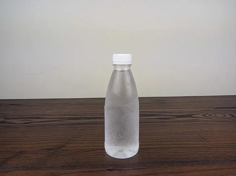 Close up cold plastic drink bottle on wooden table Stock Photos