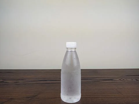 Close up cold plastic drink bottle on wooden table Stock Photos