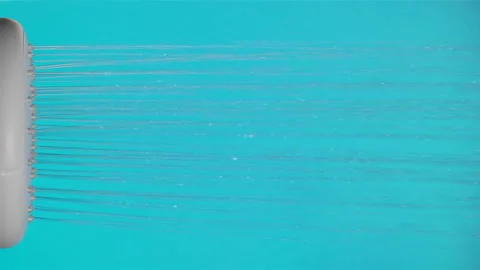 Close-up of a cold water running from a shower head. Isolated on blue Stock Footage 234137443
