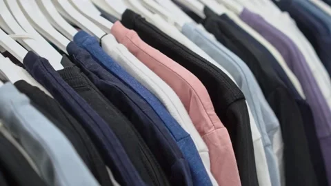 Close-up of a collection of knitted multi-colored sweaters and blouses hanging Stock Footage 191580884