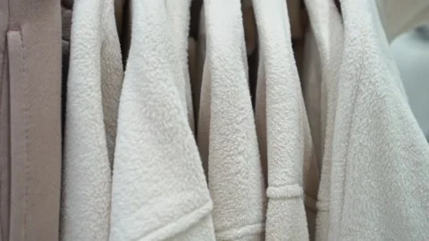 Close-up of a collection of knitted multi-colored sweaters and blouses hanging Stock Footage 193529072