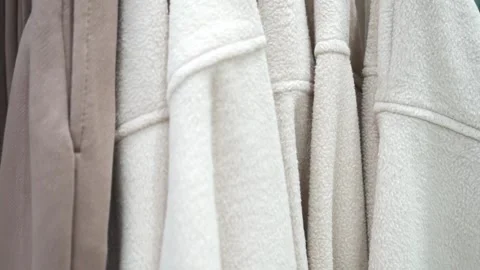 Close-up of a collection of knitted multi-colored sweaters and blouses hanging Stock Footage 194093840