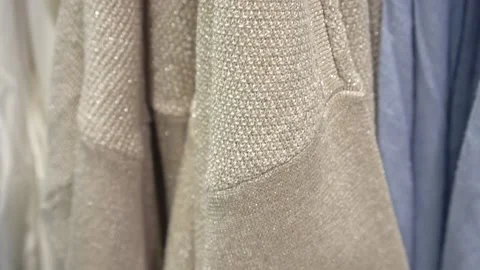 Close-up of a collection of knitted multicolored sweaters hanging on a clothes Stock Footage 194562727