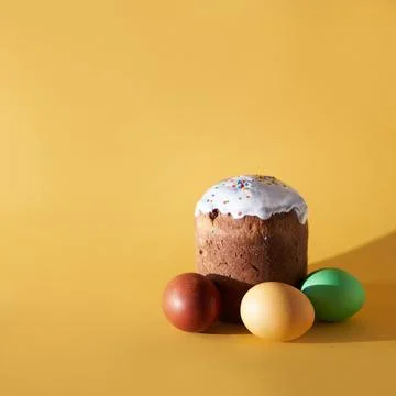 Close-up of colored Easter eggs and kulich on a yellow background. With a space Stock-Fotos