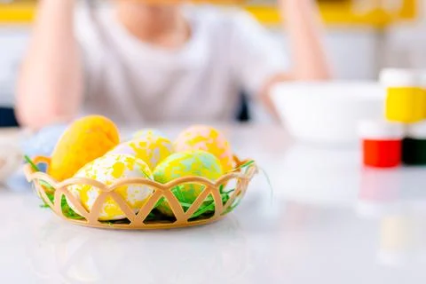 Close-up colored Easter eggs in little basket paints and kids hands on Foto stock