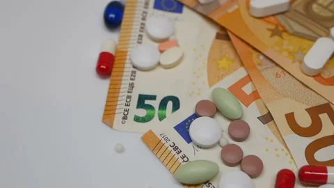 Close up, colored pills rotating on 50s euro banknotes from the right side Stock Footage 86178019