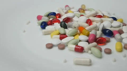 Close up, colored pills rotating, white background Stock Footage 85742406