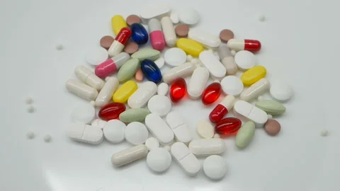 Close up, colored pills rotating, white background Stock Footage 85742600
