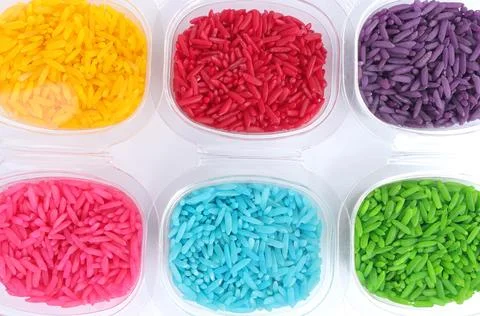 Close up of colored rice in plastic cup on a white background.  Stock Photos