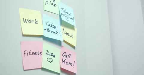 Close-up of colored stickers with notes written with a marker on a gray board Stock Footage 132583103