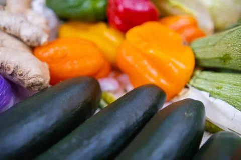 Close-up of colorful bell peppers, cucumbers, zucchini, and ginger roots Stock Photos