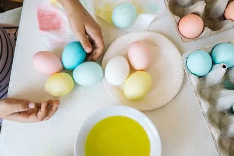 Close up colorful dyed easter eggs in child hands. Child prepares for Easter and Stock Photos