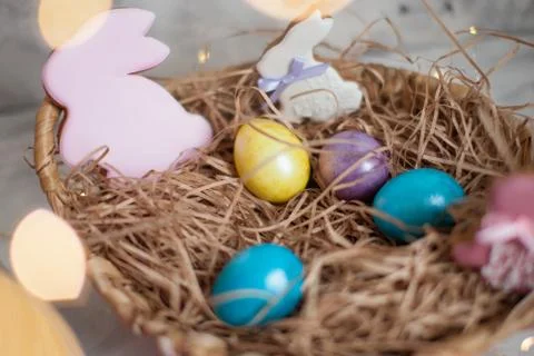 Close up of colorful Easter eggs in a basket with gingerbread as a rabbit Stock Photos