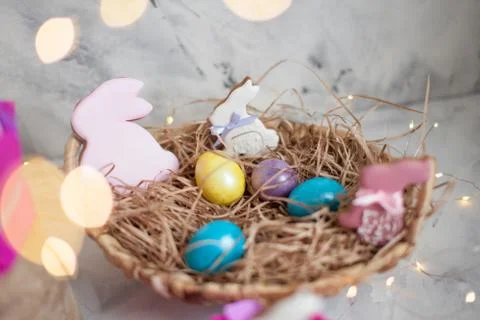 Close up of colorful Easter eggs in a basket with gingerbread as a rabbit Stock Photos