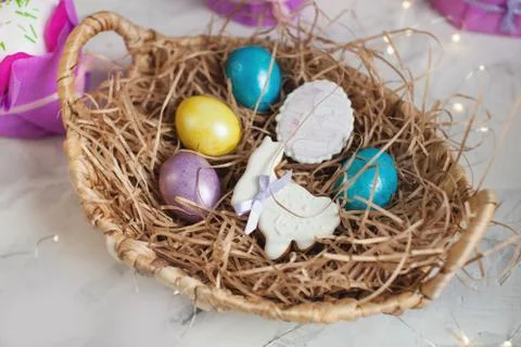 Close up of colorful Easter eggs in a basket with gingerbread as a rabbit Stock Photos