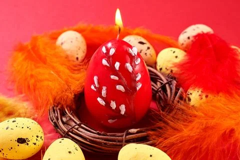 Close Up of Colorful Easter Eggs with decorated red candle in the nest with c Stock Photos