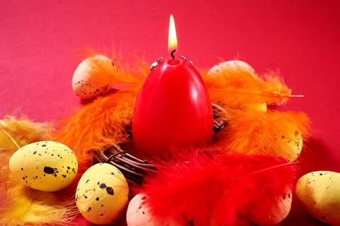 Close Up of Colorful Easter Eggs with decorated red candle in the nest with c Stock Photos