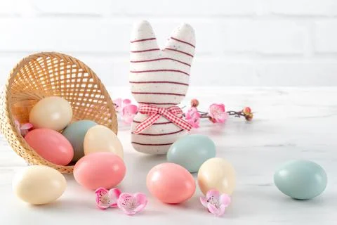 Close up of colorful Easter eggs in the nest with pink plum flower. Stock Photos