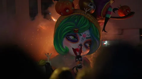 Close-up of colorful falla ninot face with fire and sparks during Las Fallas Stock Footage 336722245