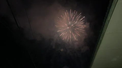 Close-up Of Colorful Fireworks Exploding In Night Sky From Residential View Stock Footage 336525657