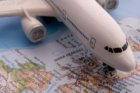 Close up of colorful map with miniature plane highlighting Glasgow, Scotland Stock Photos